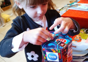 Dziewczynka wrzuca pieniądze do puszki