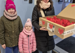 Mama z córkami trzyma pudełko z serduszkami