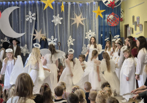 grupa uczniów podczas występu jasełkowewgo dla przedszkolaków, dzieci w strojach aniołków