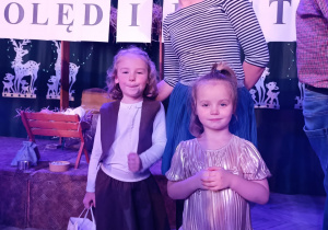 nauczyceilak i dwie dziewczynki pozują do wspólnego zdjęcia , w tle zimowa dekoracja i napis