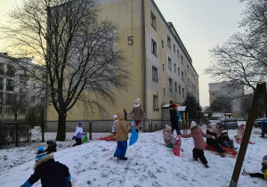 grupa dzieci podczas zabaw na śniegu na górce