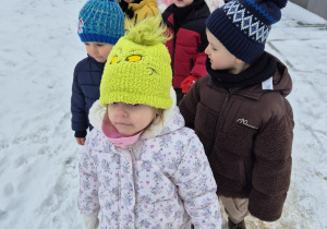 grupa przedszkolaków , stoją w parach na dworze, wychodzą na zimowy spacer