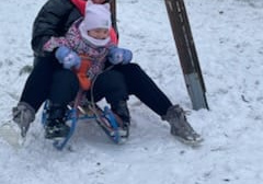 nauczycielka i dziecko zjeżdzają razem na sankach