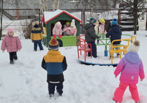 grupa dzieci w przedszkolnym ogrodzie , bawią się na śniegu