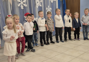 grupa dzieci prezentuje występ świateczny rodzicom, są ubrane elegancko