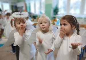 trzy dziewczynki przebrane za aniołki, puszczają "całuski"