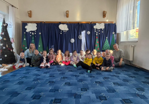 grupa dzieci, nauczycielka i pani bibliotekarka pozują do wspólnego zdjęcia w bibliotece