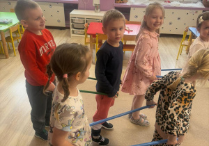 grupa dzieci w parach podczas aktywności z patyczkami gimnastycznymi