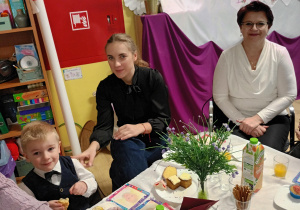 Po części artystycznej, dziadowie z wnuczętami siedzą przy stolikach podczas słodkiego poczęstunku. Celebrują wspólny czas i pozują do zdjęć.