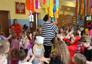 Dzieci tańczą w trakcie balu. Na drugim planie animator puszcza bańki mydlane.