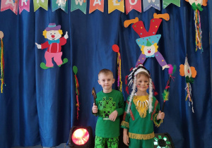 Dzieci pozują do zdjęcia w strojach karnawałowych.