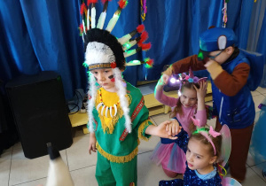 Dzieci pozują do zdjęcia w strojach karnawałowych.