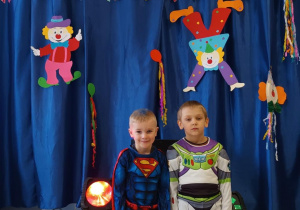 Dzieci pozują do zdjęcia w strojach karnawałowych.