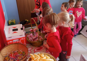 Dzieci częstują się słodyczami, które otrzymały za zużyte baterie.