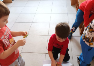 Chłopiec wrzuca do pudełka zużyte baterie.