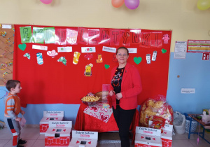 Prowadząca pozuje do zdjęcia na tle tematycznej dekoracji.