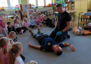 Strażak prezentuje jak wykonać pozycję bezpieczną.