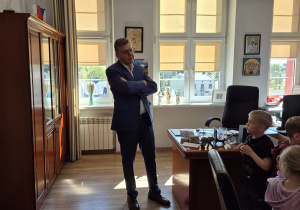 Burmistrz stoi przed dziećmi i pozuje do zdjęcia.