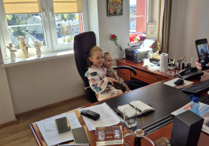 Dzieci pozują do zdjęcia siedząc na fotelu Pana Burmistrza.