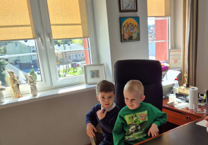 Dzieci pozują do zdjęcia siedząc na fotelu Pana Burmistrza.