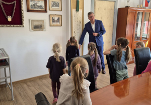 Dzieci pozują do zdjęcia siedząc na fotelu Pana Burmistrza.