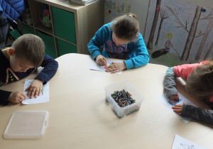 troje dzieci koloruje obrazki o tematyce recyklingowej