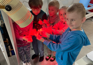 Dzieci oświetlone są specjalistyczną lampą do rehabilitacji.