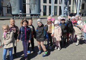 Dzieci z grupy "Duszki' pozują do zdjęcia przed budynkiem Centrum Nauki i Techniki EC1 w Łodzi.
