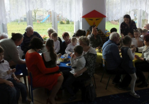 dziadkowie i babcie przy stolikach podczas poczęstunku